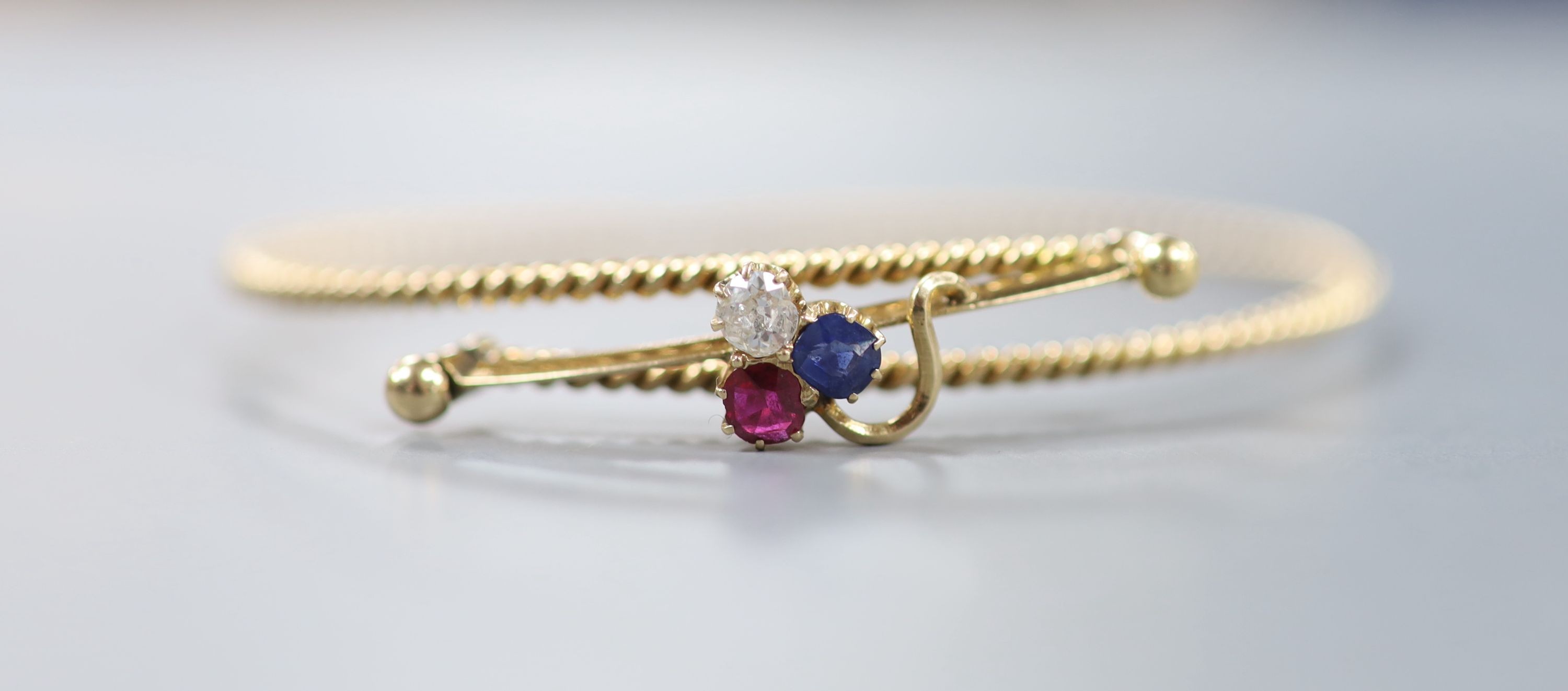 An early 20th century Russian 56 zolotnik yellow metal, ruby, sapphire and diamond 'clover' set articulated bangle